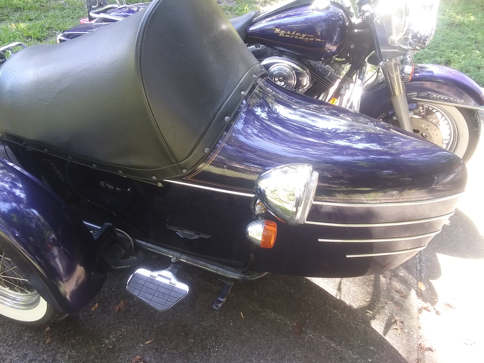 Close-up of a black motorcycle with a sidecar on a grassy background