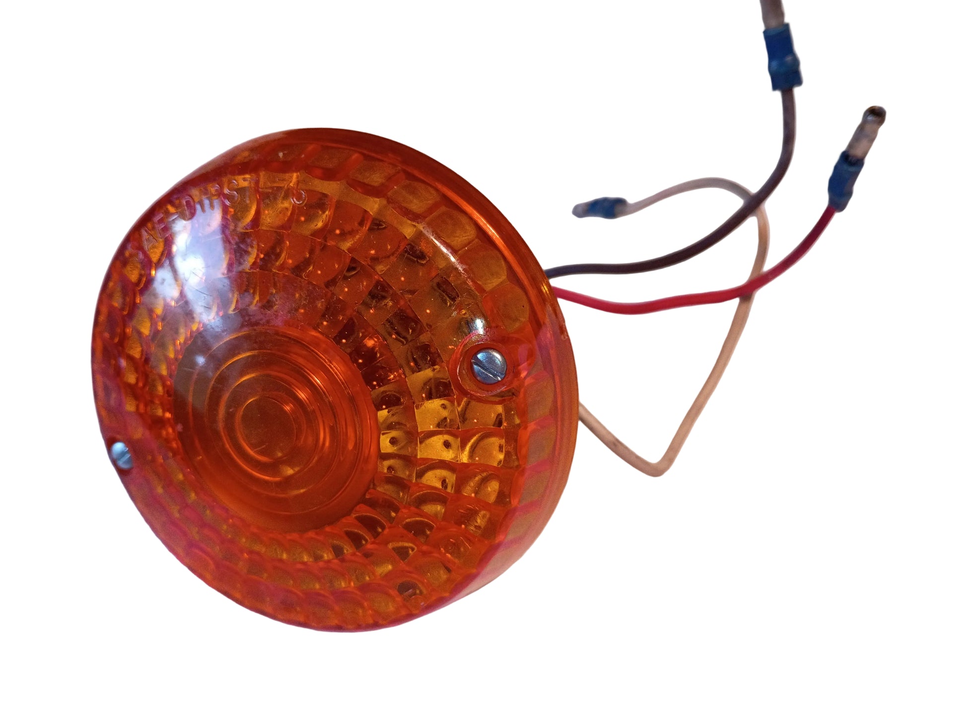 An amber/orange circular motorcycle or utility signal light with attached red, black, and beige wires and blue connectors, photographed on a white fabric surface.