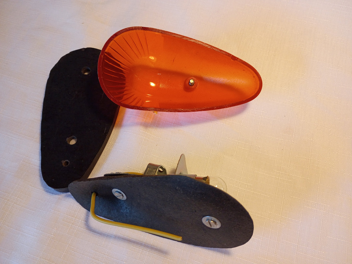 Orange reflector and black mounting bracket on a white background